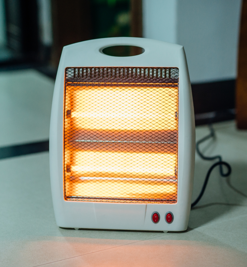 Portable electric space heater glowing on the floor, illustrating space heater safety for Philly homeowners